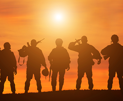 Military soldiers on a hill during sunset